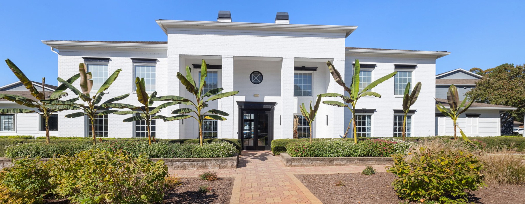 a large white building with a brick walkway